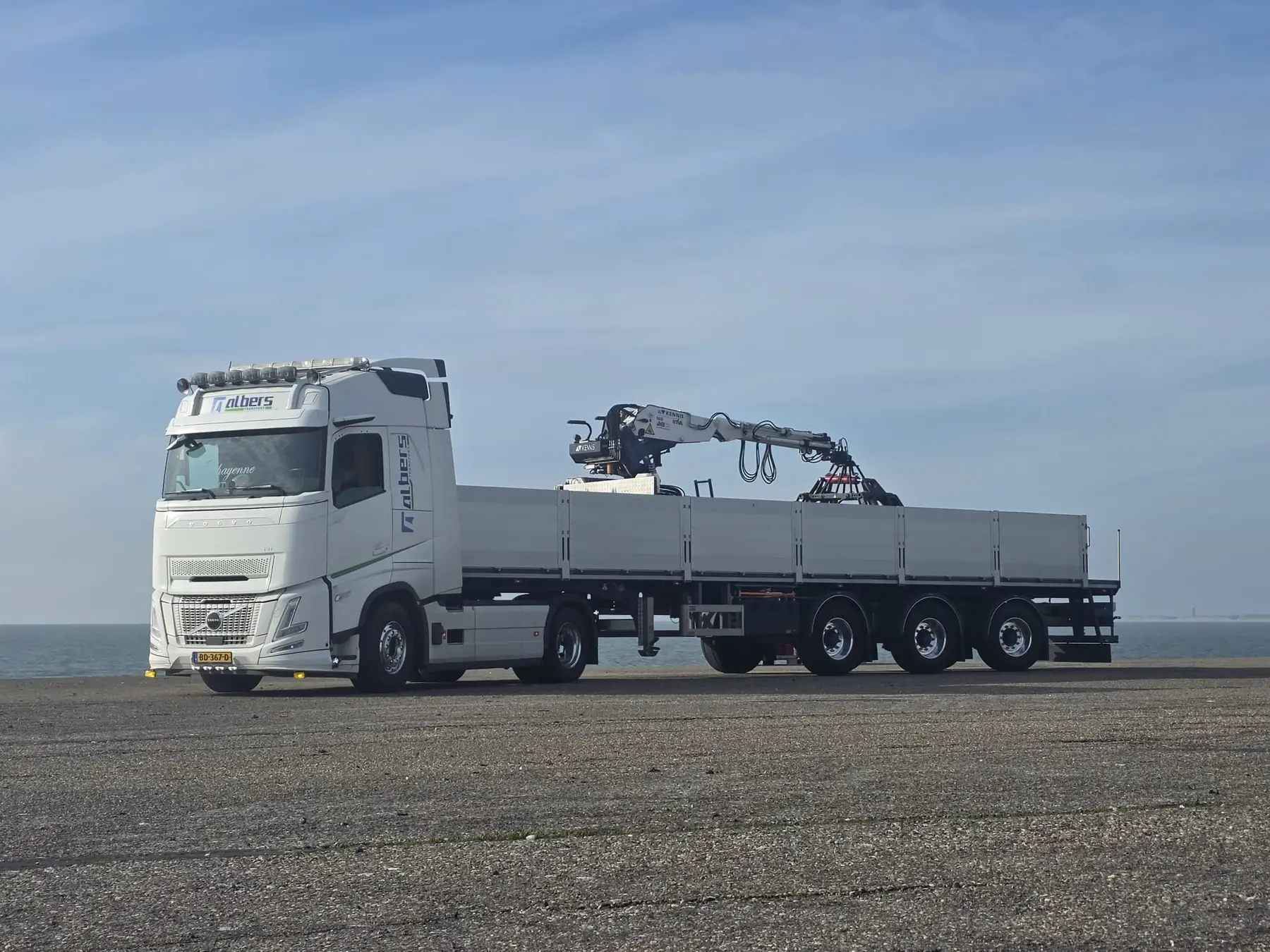 Albers-vrachtwagen met autolaadkraan aan de kust