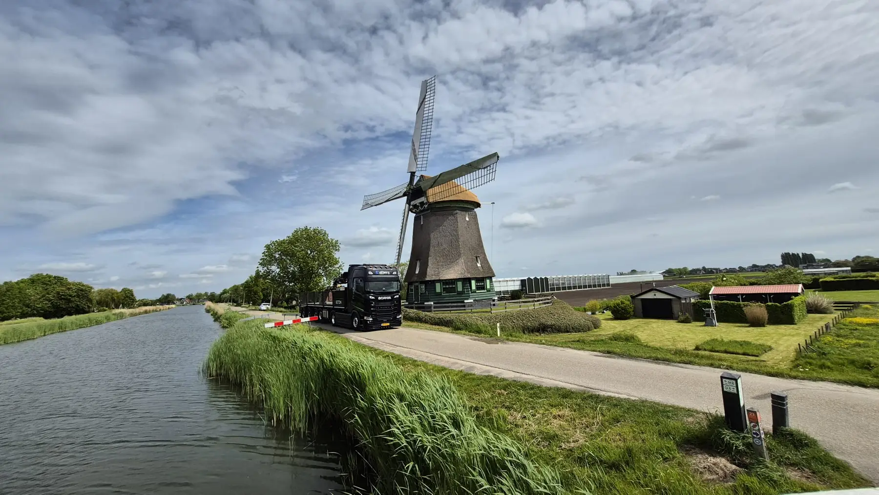 Albers-vrachtwagen op een landweg langs een Hollandse molen